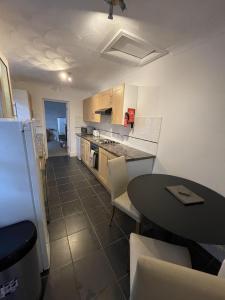 a kitchen with a table and a table and a dining room at Amaya Two - Spacious, ground floor apartment with a large patio area. in Lincolnshire