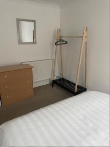 a bedroom with a bed and a dresser and a mirror at Amaya Two - Spacious, ground floor apartment with a large patio area. in Lincolnshire