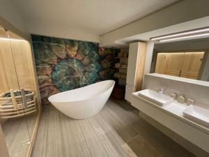 La salle de bains est pourvue d'une grande baignoire et d'un lavabo. dans l'établissement Luxuriöses Loft mit großer Sonnenterrasse & Sauna, à Munich