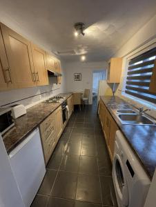 a kitchen with a sink and a stove top oven at Amaya Two - Spacious, ground floor apartment with a large patio area. in Lincolnshire