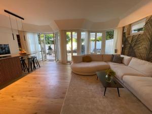 ein Wohnzimmer mit einem Sofa und einem Tisch in der Unterkunft Luxuriöses Loft mit großer Sonnenterrasse & Sauna in München