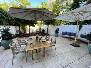 un patio con mesa, sillas y sombrillas en Luxuriöses Loft mit großer Sonnenterrasse & Sauna, en Múnich