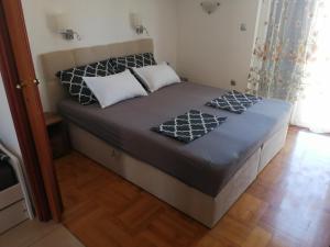 a bed with two pillows on it in a room at Apartmani Slavica in Jezera