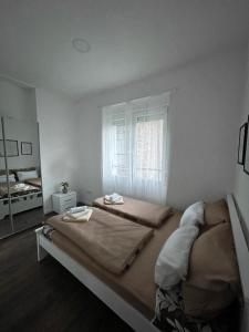 ein Schlafzimmer mit einem großen Bett und einem Fenster in der Unterkunft Allure of Belgrade (80m2-861ft2) in Belgrad