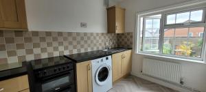 a kitchen with a washing machine and a window at 1st Floor Flat Bennetthorpe Overlooking Doncaster Racecourse Free Parking in Doncaster