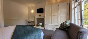 um quarto com uma cama, um sofá e uma janela grande em 1st Floor Flat Bennetthorpe Overlooking Doncaster Racecourse Free Parking em Doncaster