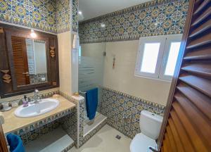 W łazience znajduje się umywalka, toaleta i lustro. w obiekcie Charming Suite Central to Downtown and Airport w mieście Le Bardo