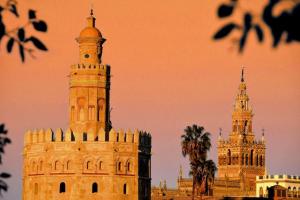 een gebouw met een klokkentoren en twee andere gebouwen bij Spalis Suite Loft de lujo en el centro histórico in Sevilla