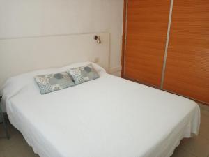 a white bed with a pillow on top of it at Apartamento en Puerto Rico in Puerto Rico de Gran Canaria