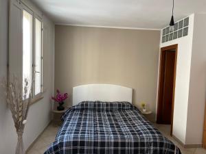 a bedroom with a bed with a plaid blanket at Civico 2 in Sassari