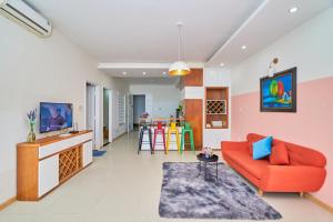 ein Wohnzimmer mit einem roten Sofa und einer Küche in der Unterkunft Pooh House 6 - Back Beach apartment in Vũng Tàu