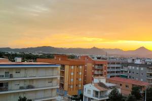 a sunset over a city with buildings and mountains at RELAX in Bellreguart