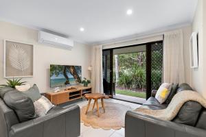 a living room with two couches and a tv at Tropical Retreat in 2 Bedroom Townhouse in Noosaville