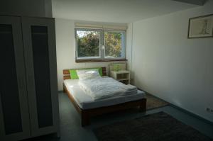 ein kleines Schlafzimmer mit einem Bett und einem Fenster in der Unterkunft Zweizimmerwohnung nah der Messe in Düsseldorf