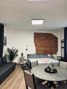 ein Wohnzimmer mit einem Bett, einem Tisch und einem Sofa in der Unterkunft Regis B&B Appartamenti centro storico in Chivasso