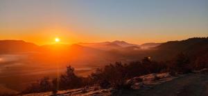 a sunset over a mountain range with the sun setting at Izarrate in Apellániz