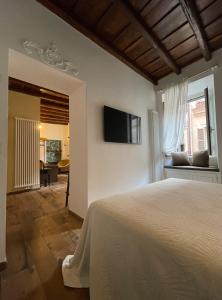 - une chambre avec un lit et une télévision murale dans l'établissement Suite La chiostrina al Cedro, à Rome