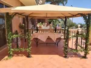 a table under an umbrella on a patio at Hotel Casa Del Gourmet in Siderno Marina