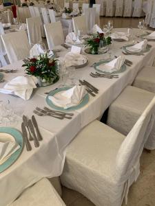 a group of tables with white table cloths and napkins at Hotel Casa Del Gourmet in Siderno Marina