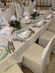 a group of tables with white table cloths and napkins at Hotel Casa Del Gourmet in Siderno Marina