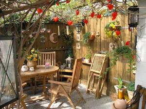 een patio met een tafel en stoelen en een hek bij Haus mit Lilie und Rose in Westerdeichstrich