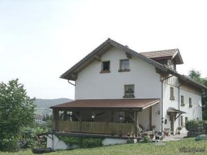 a large white house with a porch on top of it at Ferienwohnung Schäfer in Rinchnach