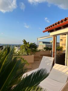 a balcony with a bench and the ocean in the background at Candia Hotel in Chania Town