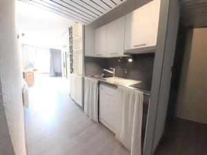 una cocina con armarios blancos y fregadero en Studio Piau-Engaly, 1 pièce, 6 personnes - FR-1-457-177, en Aragnouet