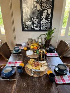 una mesa de madera con un plato de comida. en Chambres d'hôtes Place Balanant, en Buzançais
