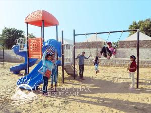 a group of people playing on a playground at Queen of Thar Desert Camp in Sām