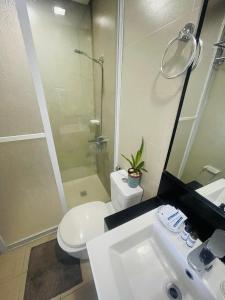 a bathroom with a toilet and a sink and a shower at Magerife’s Home in Boracay