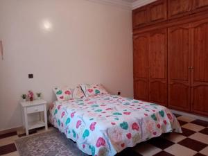 Grand Appartement à 5 mn de la plage في أغادير: غرفة نوم بسرير وخزانة خشبية