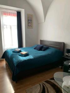 a bedroom with a bed with a blue comforter at Alžbetina 15 - DREAM apartmán in Košice