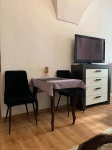 a dining room table with two chairs and a tv at Alžbetina 15 - DREAM apartmán in Košice
