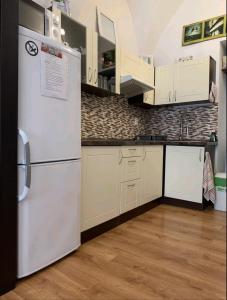 a kitchen with white cabinets and a refrigerator at Alžbetina 15 - DREAM apartmán in Košice