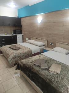 a hotel room with two beds and a kitchen at G M 3 ROOMS KENTPO in the heart of the city in Larisa