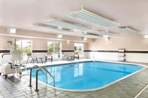 a pool in a large room with chairs and tables at Country Inn & Suites by Radisson, Marion, OH in Marion