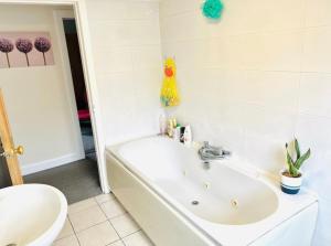 ein weißes Badezimmer mit einer Badewanne und einem Waschbecken in der Unterkunft LEITH WALK VILLA budget guest house in Edinburgh