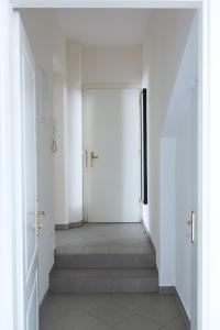 a hallway with white doors and stairs in a building at Charming City Apartment in Graz