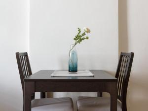 einen Tisch mit einer Vase mit einer Blume darin in der Unterkunft Charming City Apartment in Graz