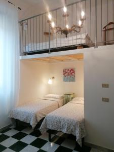 a bedroom with two beds and a chandelier at Eco Pisa Tower Guesthouse in Pisa