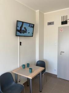 a room with a table and chairs and a tv on the wall at Hostel przy Stadionie in Jaworzno