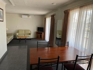 un soggiorno con tavolo e divano di Homestead Motel a Dubbo