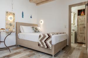 a bedroom with a bed with white sheets and a table at Elizabeth's small apartment in Naxos Chora