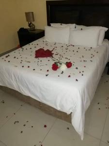 a white bed with flowers on it at Phokela Guest House in Mokopane +1 photo