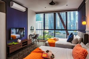 a hotel room with two beds and a large window at Scarletz Mana-Mana Suites KLCC in Kuala Lumpur