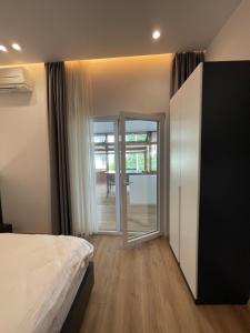 Schlafzimmer mit einem Bett und einer Glasschiebetür in der Unterkunft Ladi Rooms in Tirana