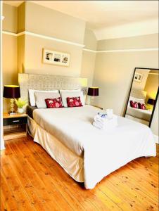ein Schlafzimmer mit einem großen weißen Bett mit roten Kissen in der Unterkunft LEITH WALK VILLA budget guest house in Edinburgh