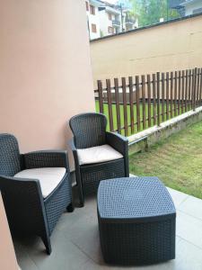 three wicker chairs and a stool on a patio at Casa Vacanza IL CICLAMINO in Borno