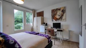 a bedroom with a bed and a desk with a computer at Huis van Steen in Lelystad